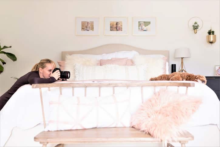 Jen Frase taking a photo of a dog lying on a bed